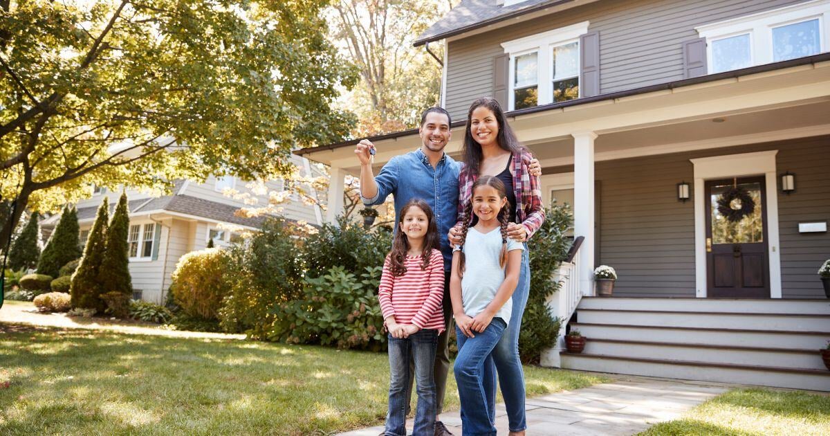 Family in front of luxury home financed with a jumbo loan in Maryland, Washington DC, or Virginia.